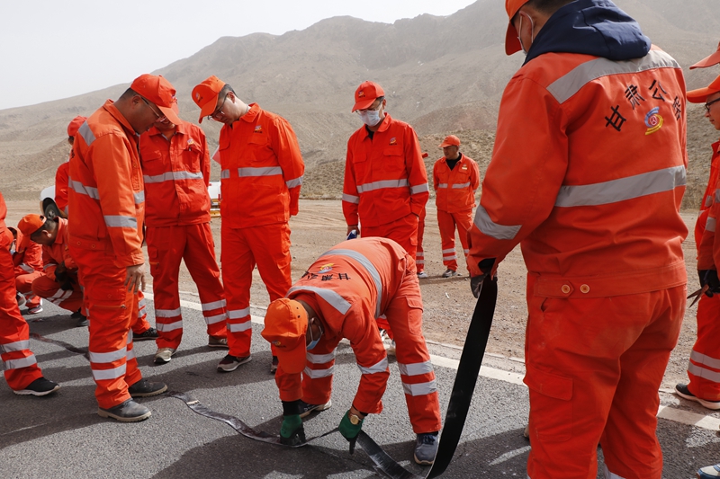 1616493679599336.jpg 民乐段技术人员现场学习贴缝带处治路面裂缝施工工艺(陈银国 摄).JPG